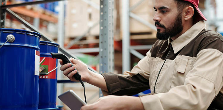 Hispanic factory worker using a barcode scanner