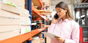 Image of latino hispanic woman on a smartphone in a warehouse